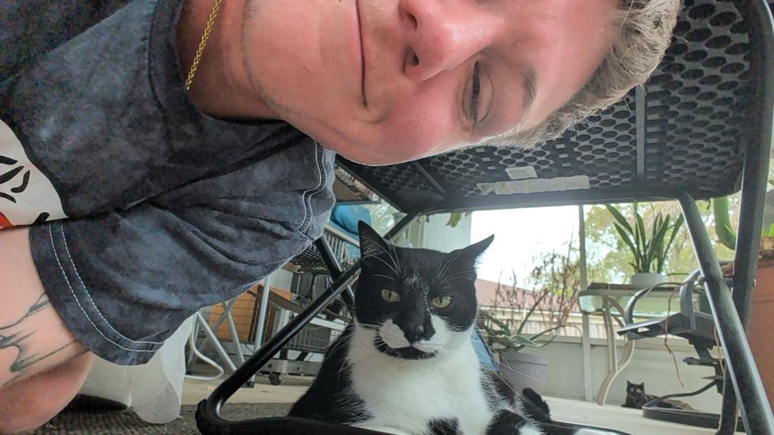 George on the porch with a tuxedo cat